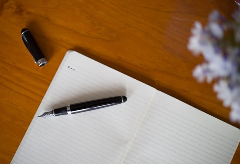 Cuaderno abierto con pluma estilográfica sobre escritorio