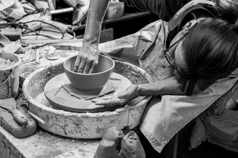 Manos trabajando cerámica en torno alfarero